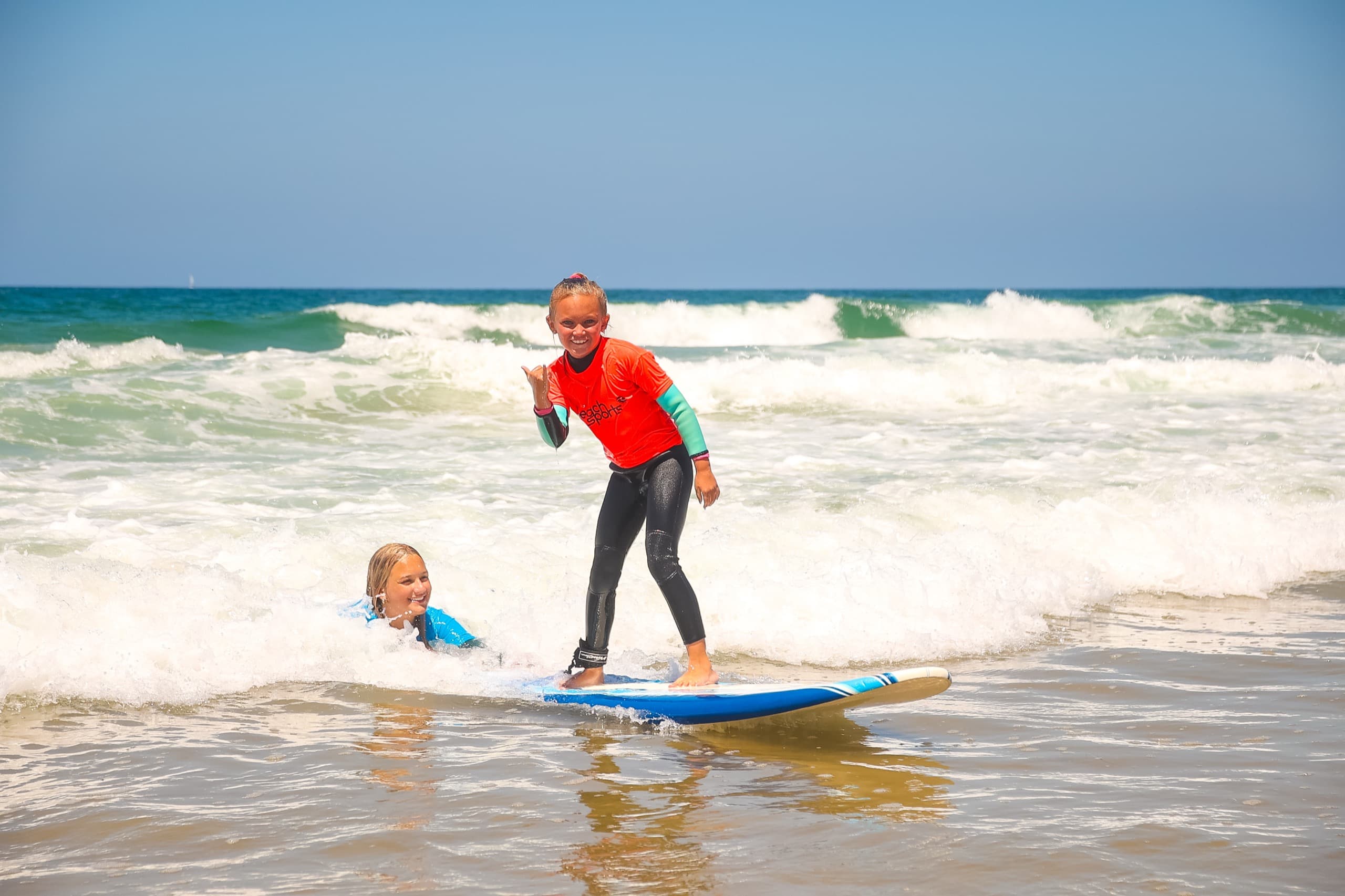A camper throwing a shaka on a wave