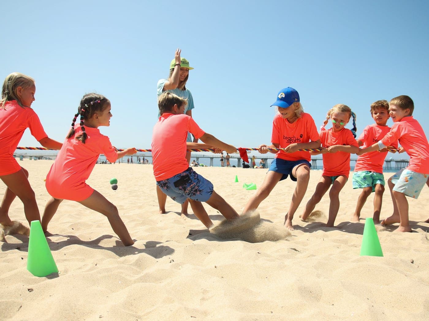 A group of BeachSports campers playing a beach tug-of-war game at a birthday party