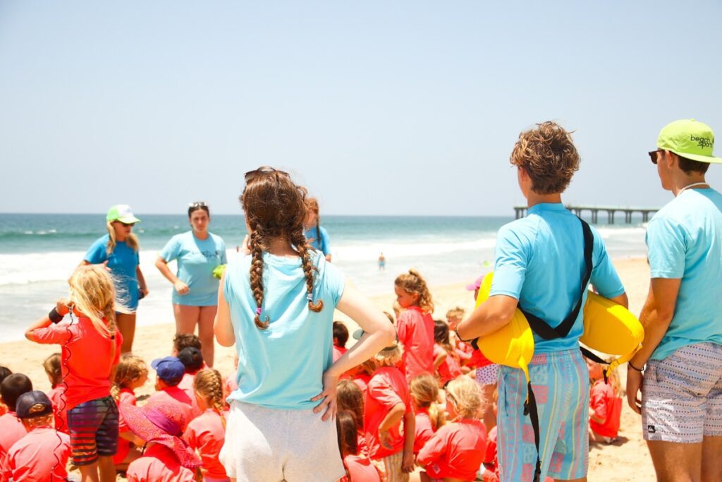 Sumer beach camp counselors instruct campers on the activities and rules