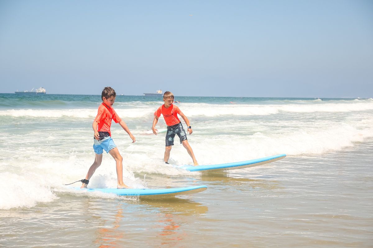 Two sports camp counselors in Hermosa Beach summer beach camp with five kids