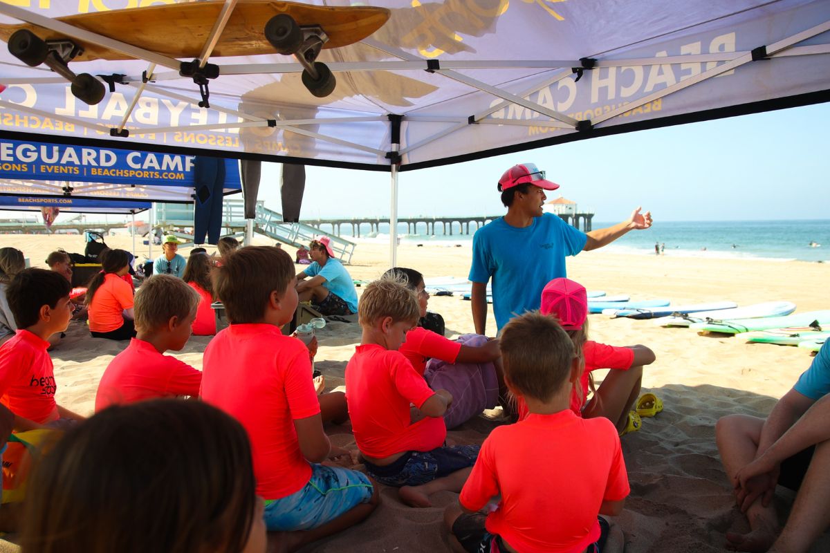 Sumer beach camp counselors instruct campers on the activities and rules